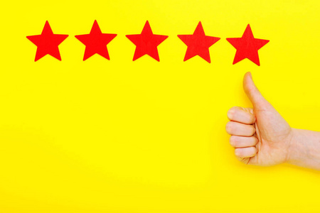 五星提升评级，客户体验理念。客户手举五星标志，提高服务等级。黄色背景下有五颗红星。满意度概念