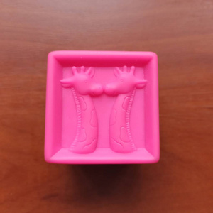 木制背景上有长颈鹿的粉红色玩具立方体