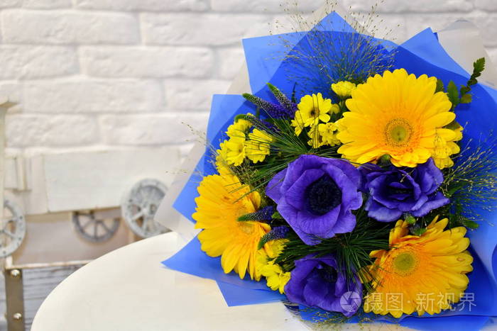 桌上一束美丽明亮的花束。娇嫩的蓝色和黄色花朵。3月8日
