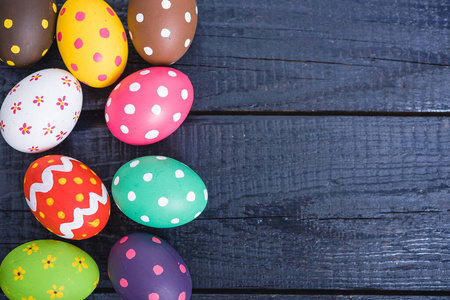 Easter eggs top view on black wooden background 