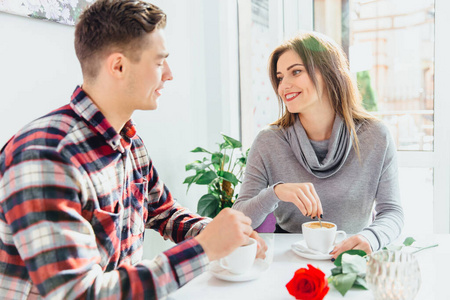 阳光明媚的周末早晨,一对幸福的情侣在咖啡厅喝着美味的咖啡,共度时光
