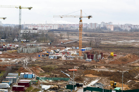 建筑工地俯视图在一个大城市里，在大型工业起重机和专业设备的帮助下，新建的住宅区有高大的房屋