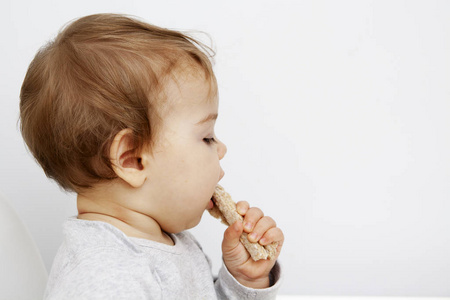 这孩子吃减肥面包。婴儿食品概念