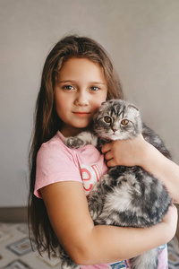 Beautiful kid with cute kitten resting at home. 