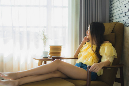 Portrait young asian woman sit on sofa chair and read book with 