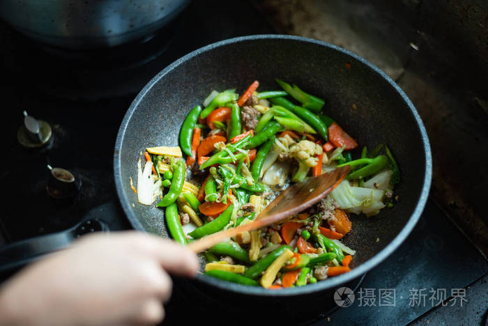 把炒菜放在厨房的平底锅上