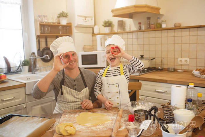戴着厨师帽的爸爸和儿子正在做饭