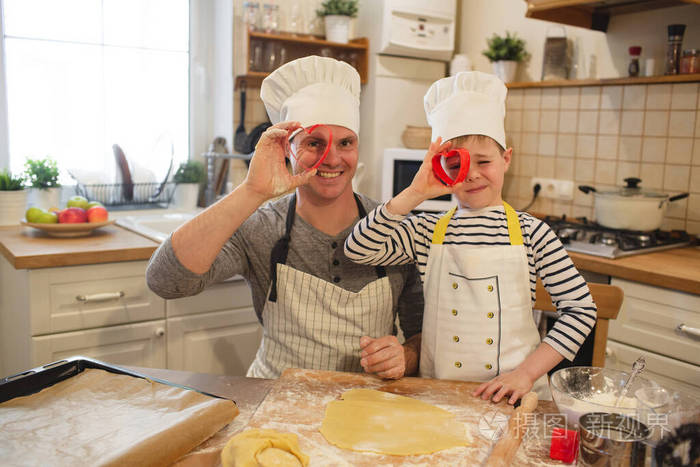 戴着厨师帽的爸爸和儿子正在做饭