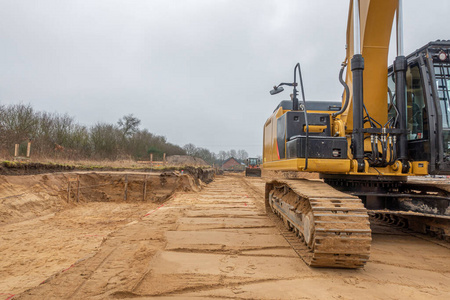  a building site there is a yellow excavator preparing the groun