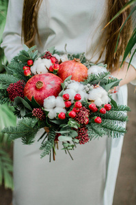 带石榴石和绿树的冬季新娘花束图片