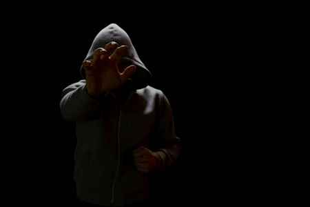 蒙面强盗伸出手去拿贵重物品照片