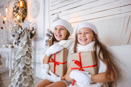 快乐的孩子们带着礼物在圣诞背景下微笑