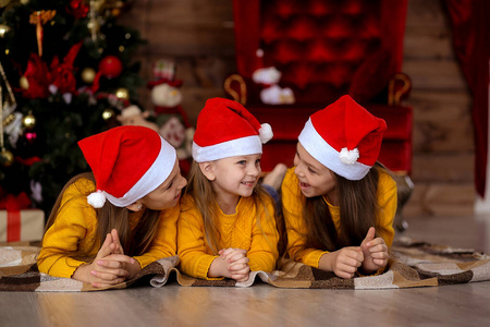 Children smiling in red hats on the background of the Christmas 