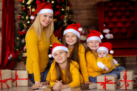 Mom and children in red hats on the background of the Christmas 