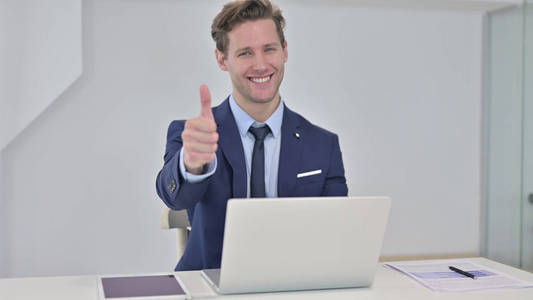 Young Businessman doing Thumbs Up in Office 