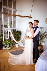 Beautiful bride in an elegant dress and groom in a waistcoat in 