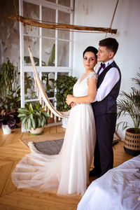 Beautiful bride in an elegant dress and groom in a waistcoat in 