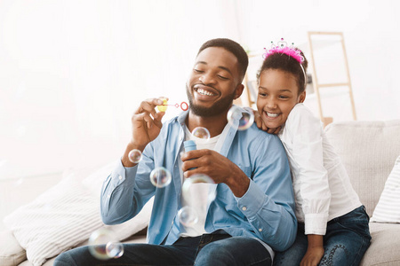 非洲裔美国人爸爸和女儿一起吹肥皂泡