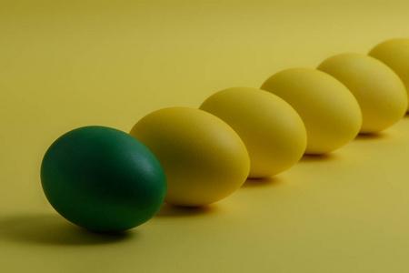 黄色背景上有五个黄色和一个绿色的鸡蛋