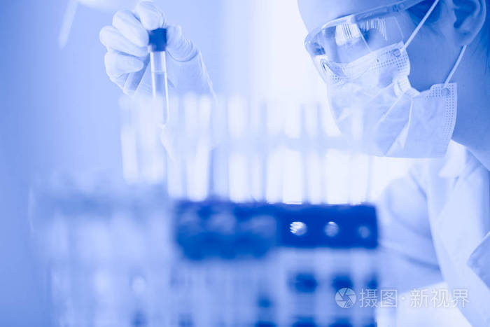 药剂师在实验室里看着绿色液体溶液试管的医学或科学研究人员或医生