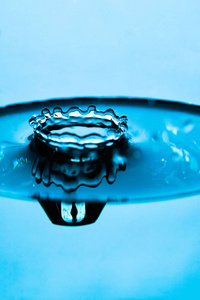 水滴飞溅在一个玻璃蓝色的颜色