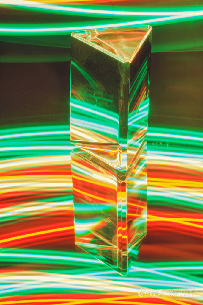 在抽象的彩色霓虹灯背景上反射的玻璃棱镜