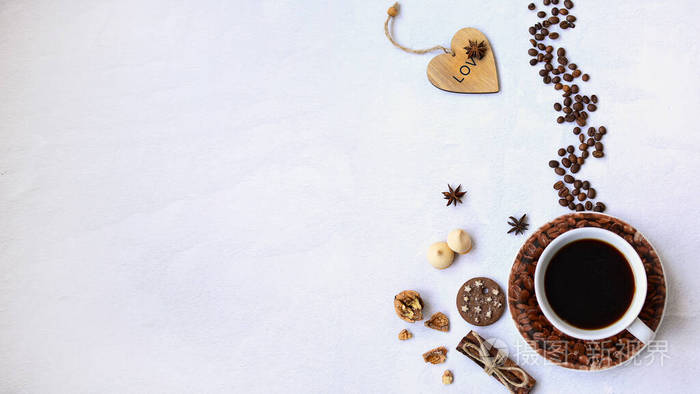 咖啡杯用烤咖啡豆曲奇核桃和浅背景的心脏制成咖啡馆概念