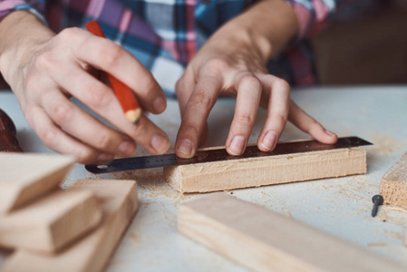 木匠用木板铅笔测量。DIY木工家具制作理念