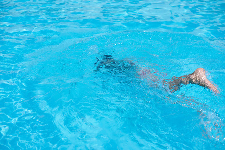 戴着潜水面具的男孩在游泳池里游泳