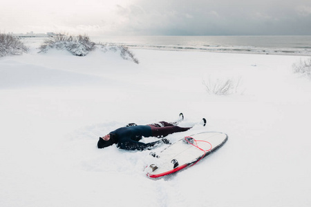 寒冷的冬天，冲浪者用冲浪板在雪地上放松。下雪天w