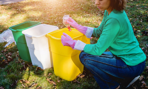 Volunteer girl sorts garbage in the street of the park. Concept 