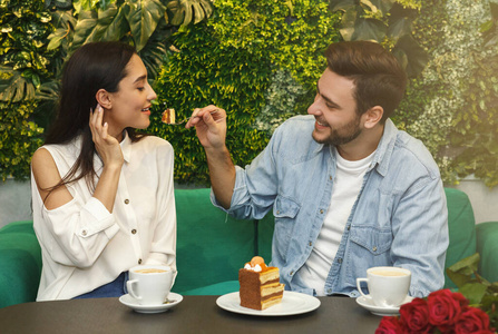 一个男人在咖啡馆里喂女朋友吃蛋糕