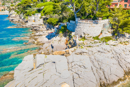 鸟瞰城市和彩色房屋坐落在利古里亚海的岩石海岸，加莫格里靠近热那亚，意大利。多岩石的海岸线被碧蓝的海水冲刷着