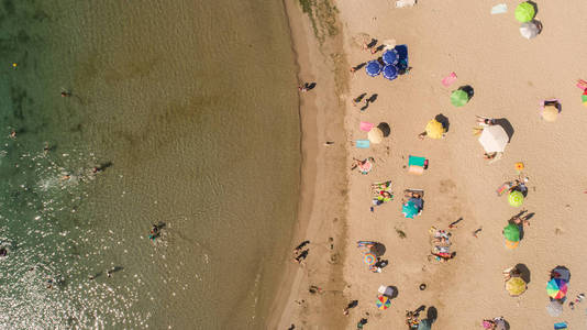 Top down view of beach with tourists and umbrellas with clear wa