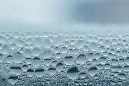 冷凝水滴在窗户玻璃上冬季湿度大.水滴从家里凝结在窗户上.