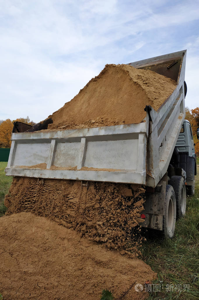 一辆自卸车在工地上卸沙子