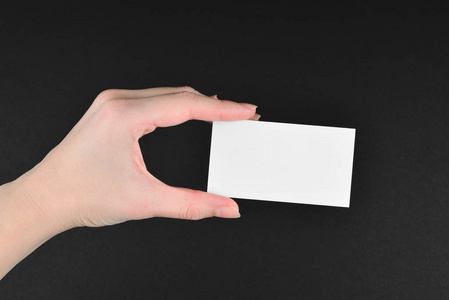 Empty card in woman hand  on a black background. 