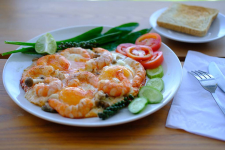 Fried eggs with prawns decorate fresh vegetables and toast