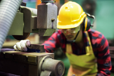 Factory mechanic worker working on lathe 