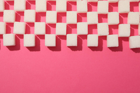 粉红色背景俯视图和文本空间上的许多方糖