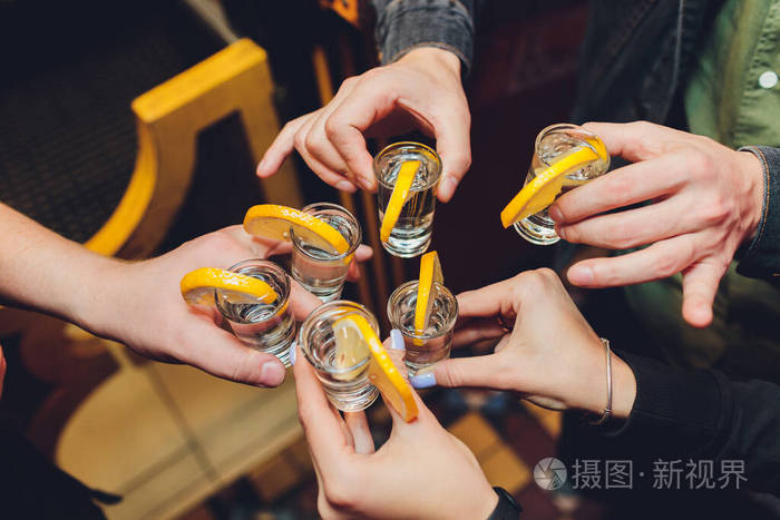 朋友们在一张黑色的旧木桌上举杯敬酒