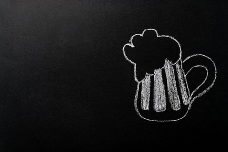 用白色粉笔在黑色黑板上画的一品脱啤酒。黑色背景的复制空间。