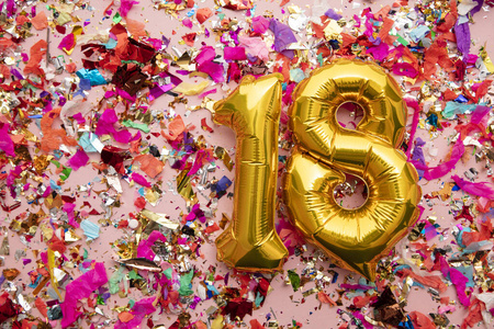 18号金色生日庆祝气球，背景是五彩纸屑