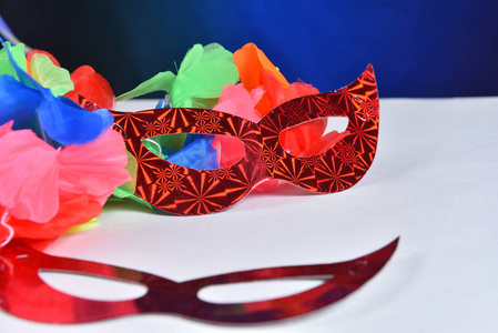 red carnival costume mask in colorful confetti and streamers on 