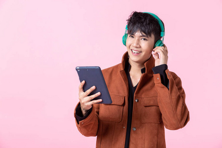 亚洲一个年轻帅气的男人戴着耳机正在听音乐