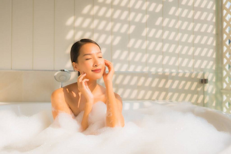 图为年轻的亚洲女人放松在浴缸里洗澡