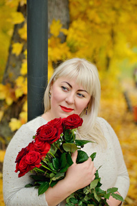 红树叶风景一个中年妇女的肖像,大尺寸,白发,手拿红玫瑰,在黄色树叶的