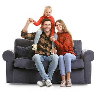 幸福的年轻一家人坐在白色背景的沙发上