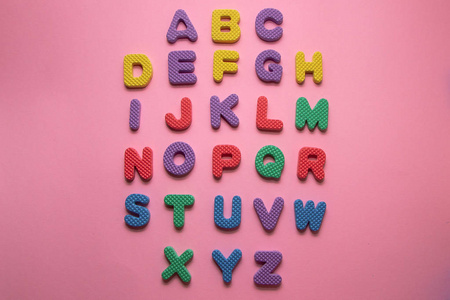 粉红色背景的彩色塑料英文字母图片