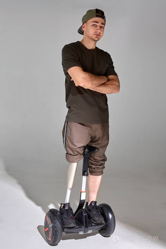 在工作室里一个残疾的年轻人在悬停板上用假肢阴影光